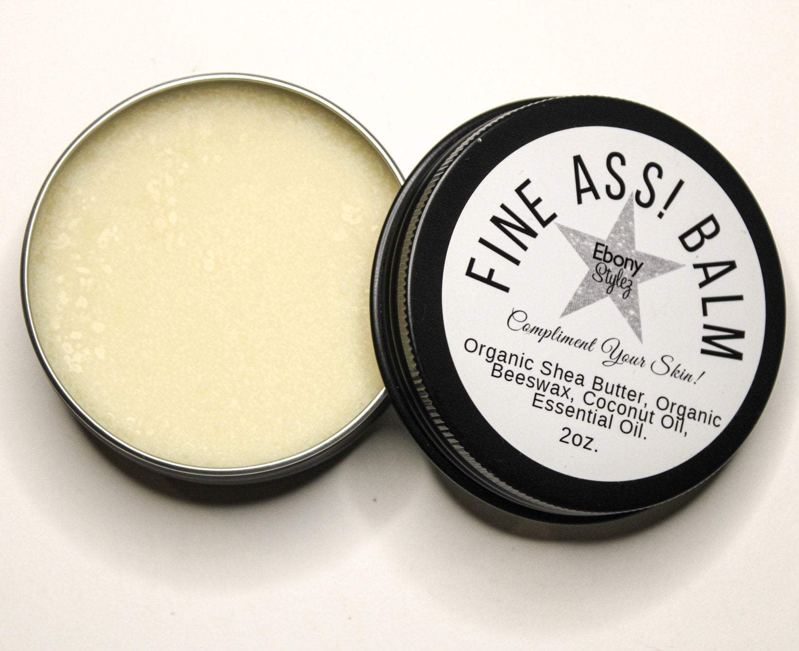 A top view of a 2oz tin container of FINE ASS! Hand & Body Balm with visible organic shea butter and beeswax labels.